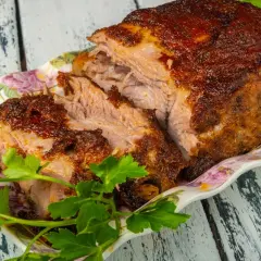Soczysta karkówka po zbójnicku w plastrach, pieczona do perfekcji, podana z ziołami. Idealna na góralską ucztę.