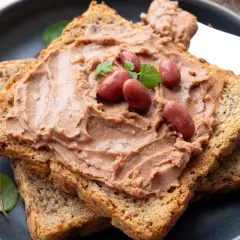 Pyszna pasta z czerwonej fasoli na chrupiących grzankach, ozdobiona fasolkami i listkami ziół. Idealna na szybką przekąskę.