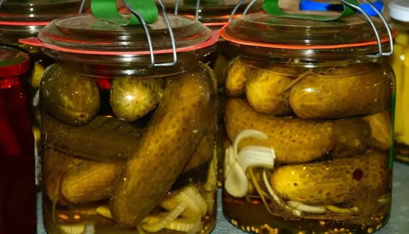 Słoiki pełne ogórków po kaszubsku, z dodatkiem cebuli i przypraw, gotowe do zimowych przetworów.