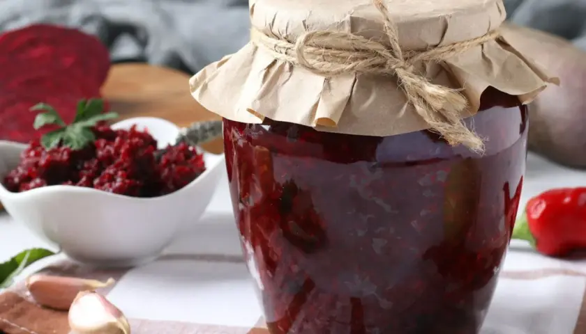 Słoik z buraczkami na zimę siostry Anieli, obok miseczka z przetartymi buraczkami, czosnek i papryka.