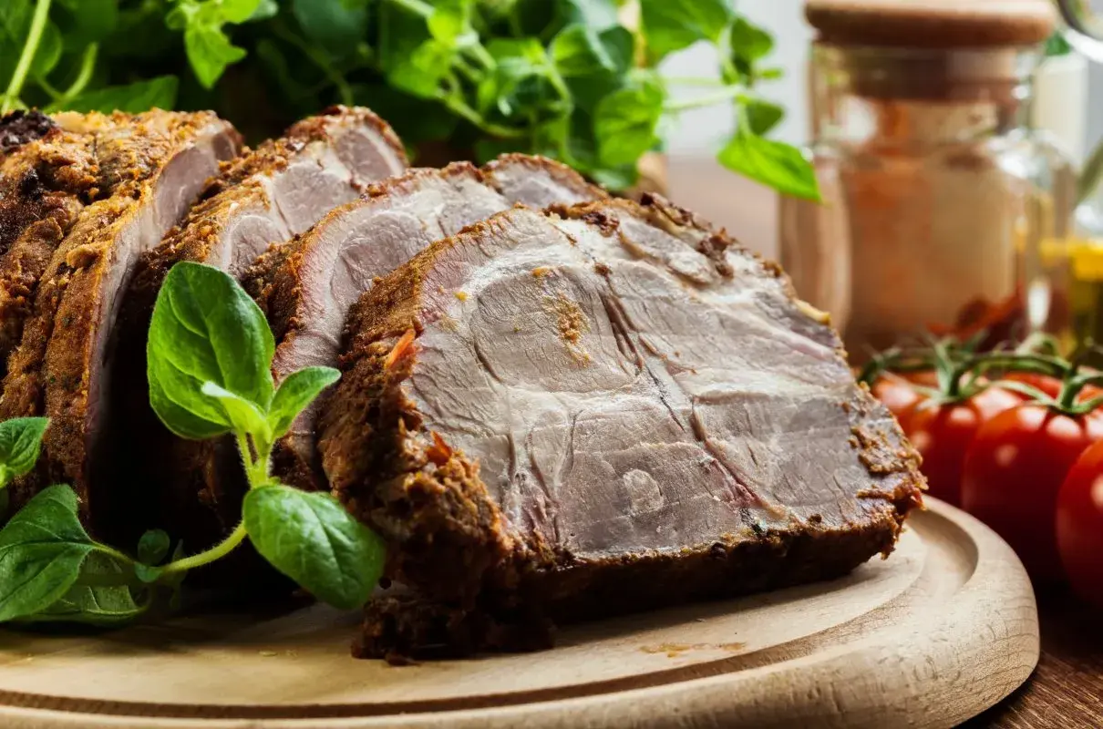 Rozpływająca się karkówka z piekarnika, soczysta i aromatyczna, podana z ziołami i pomidorkami.
