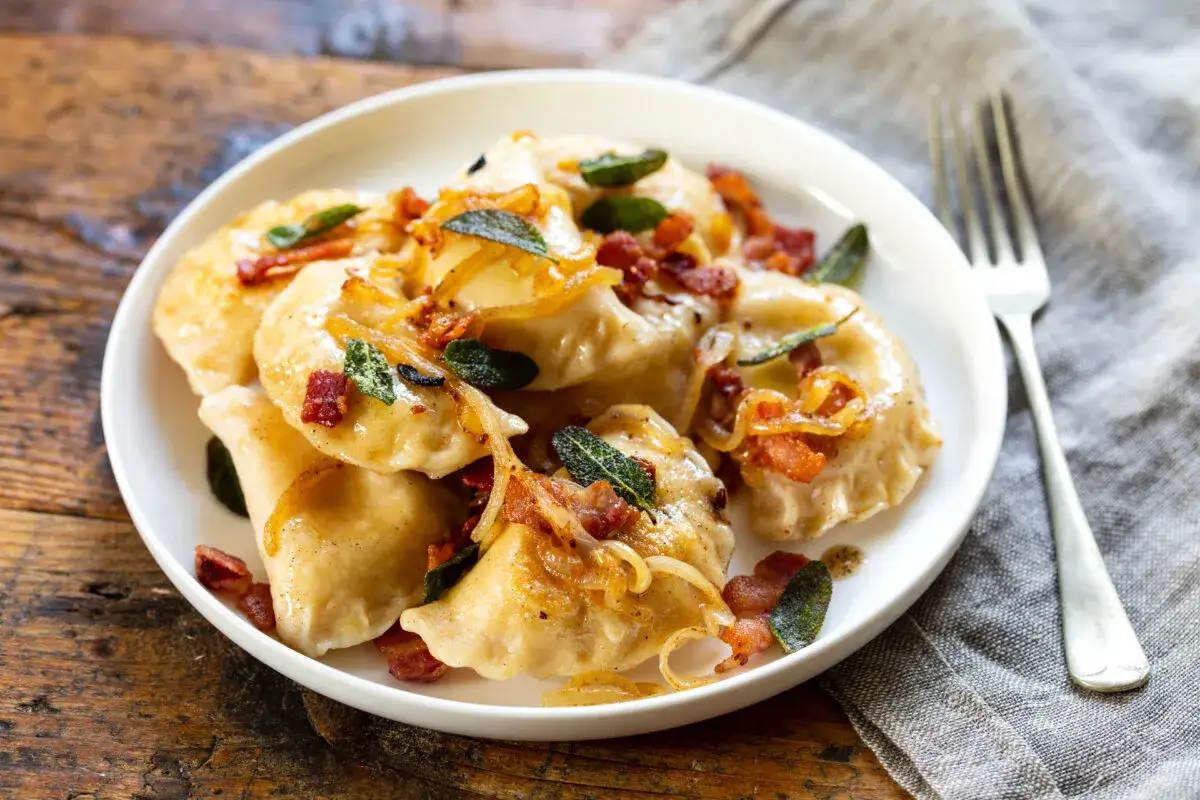 Pyszne pierogi z boczkiem i cebulką. Czy rozmrażać pierogi przed gotowaniem? Te wyglądają na świeżo zrobione, idealne do jedzenia!