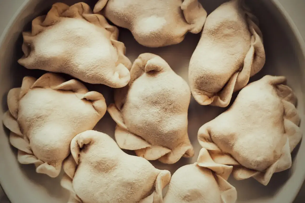 Surowe pierogi ułożone w okręgu. Idealne do zamrożenia, gdy chcesz wiedzieć, jak pakować pierogi próżniowo.