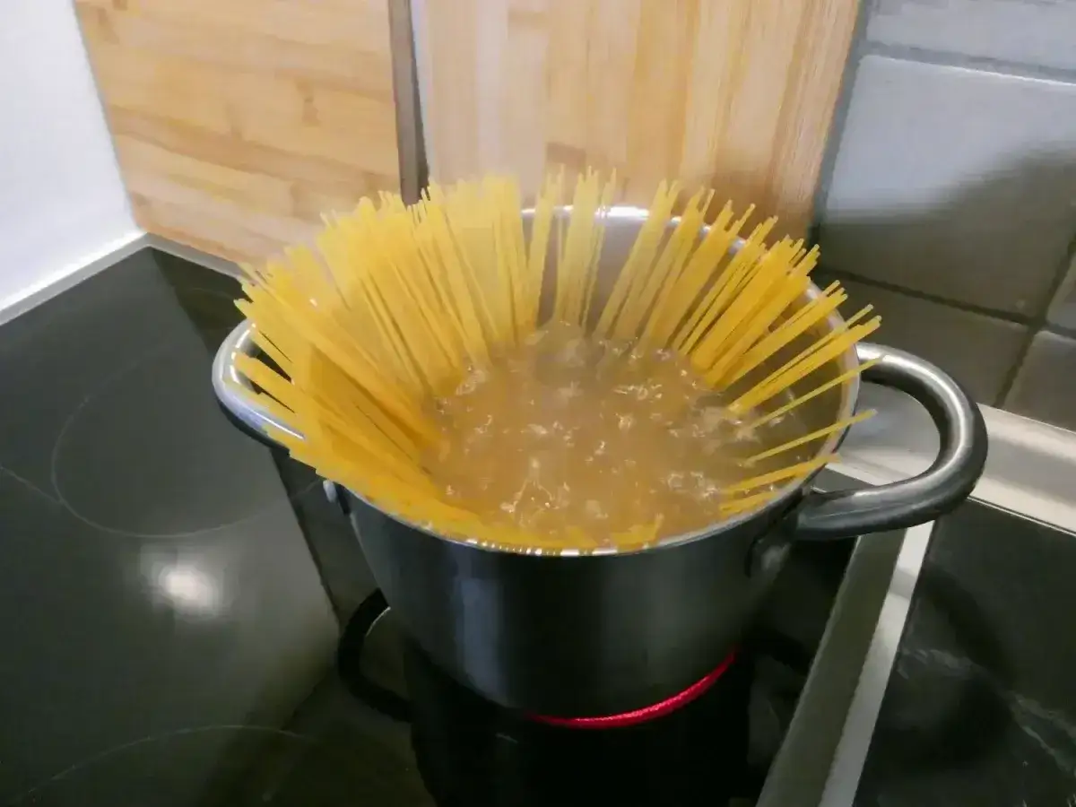 Długi makaron spaghetti gotuje się w garnku, by osiągnąć idealny makaron al dente.